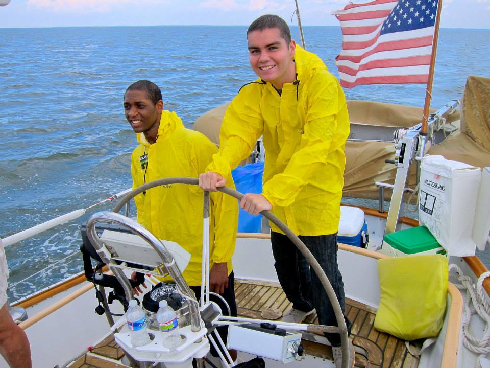 Two boys steering sail boat on the Chesapeake Bay