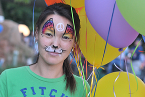 Image of a resident with festive face paint and balloons