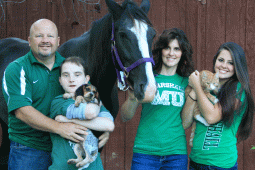 Zach Toppins family wearing green with Animals, horse, cat, and dog