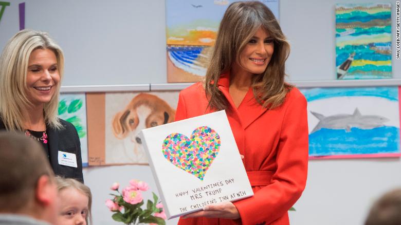 First lady Melania Trump holds up a gift as she visits with children who are currently patients at the National Institutes of Health (NIH) at The Children's Inn