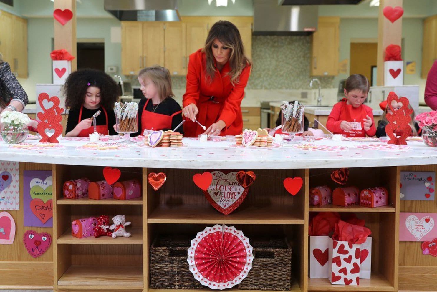 First lady Melania Trump helps decorate cookies during her visit to the Children’s Inn on Valentine’s Day