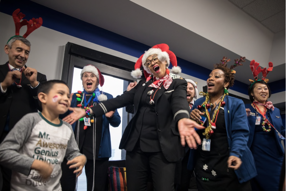 Inn resident Jordan dances with flight attendants before he boards a fantasy flight to the "North Pole."