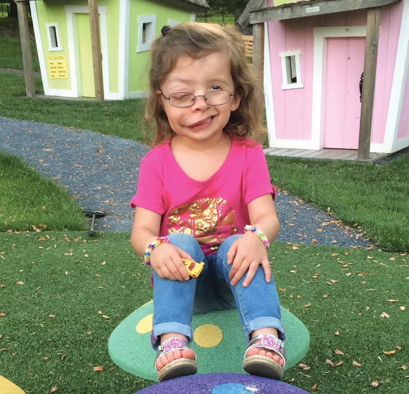 A little girl sitting in a playground at The Inn