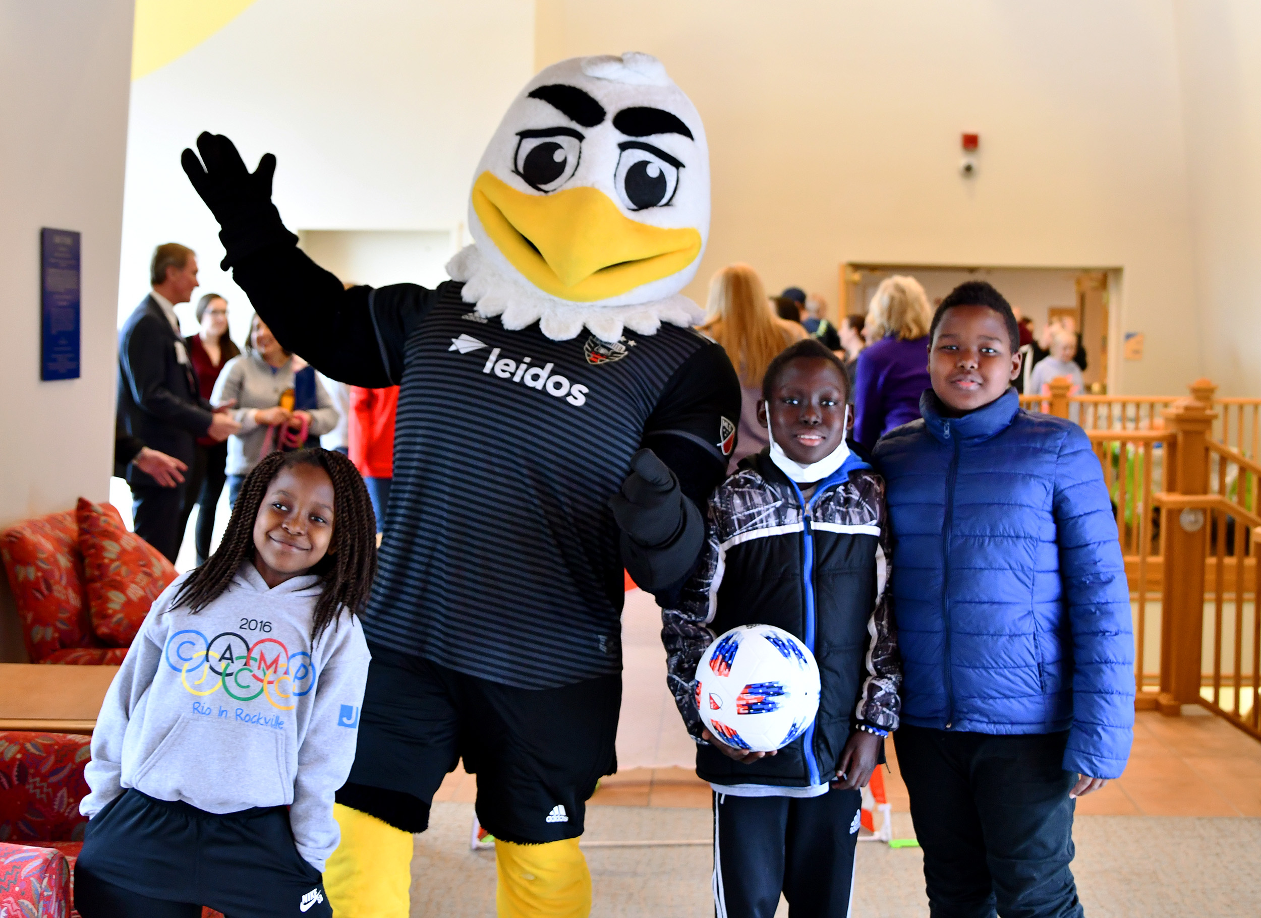 Eagle mascot with three kids pose for a photo