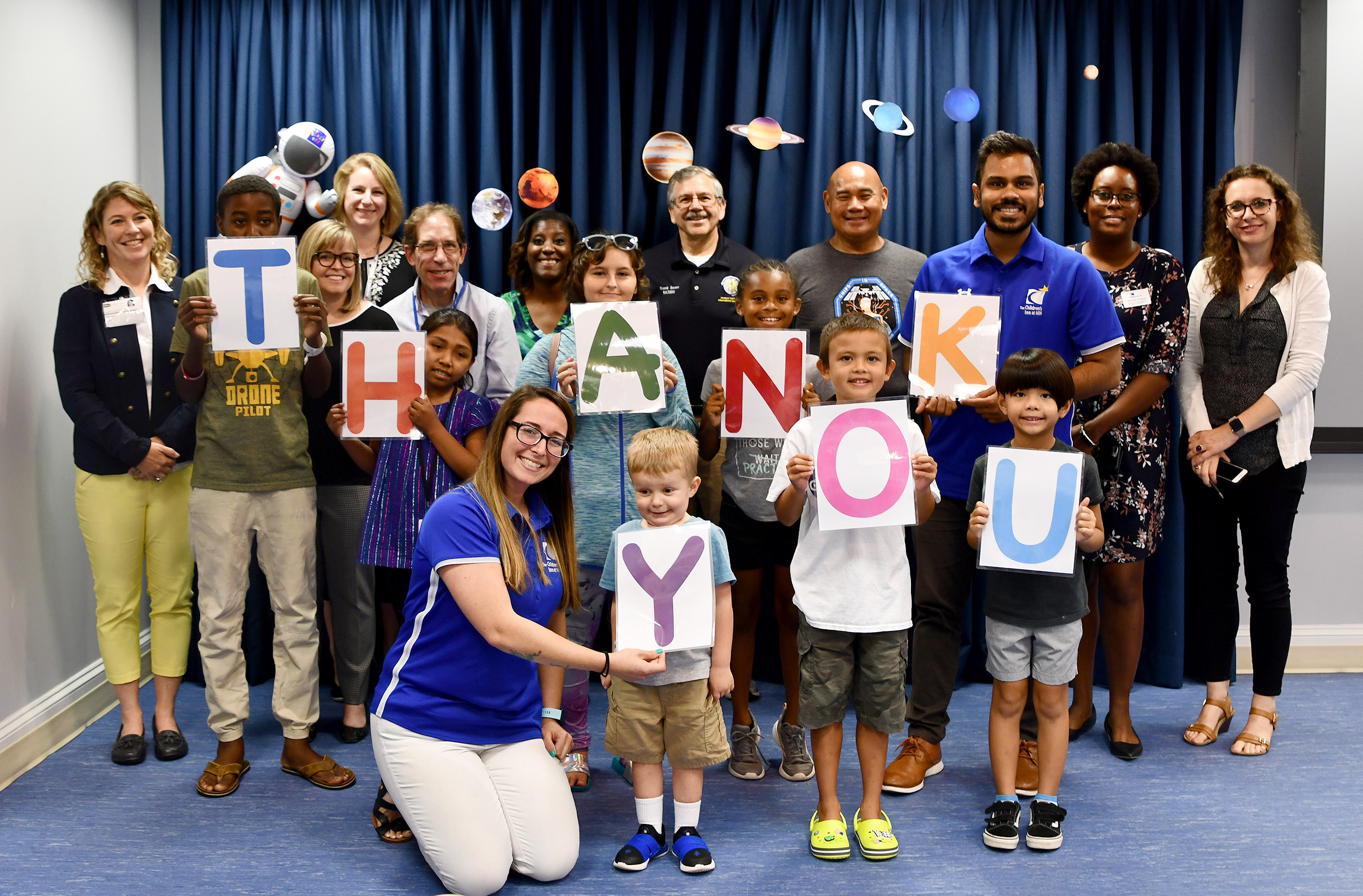 Children holding letters spelling out Thank You for the Astronaut