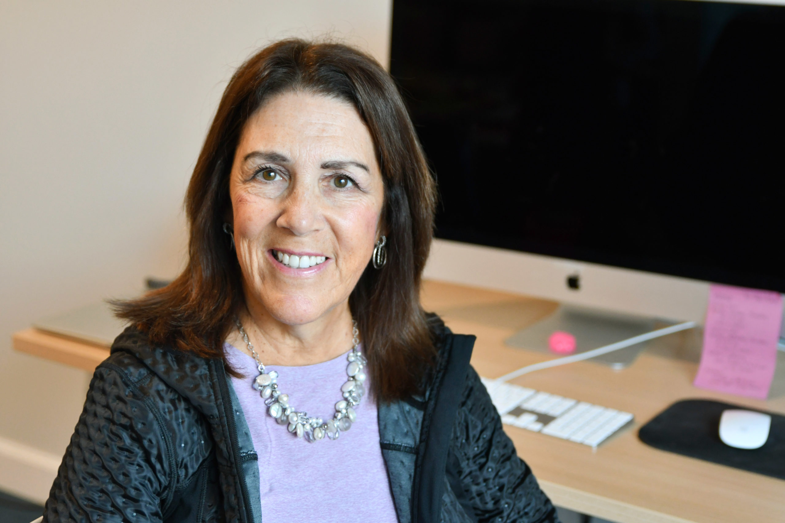 Phyllis Rienzo sitting at her desk inside