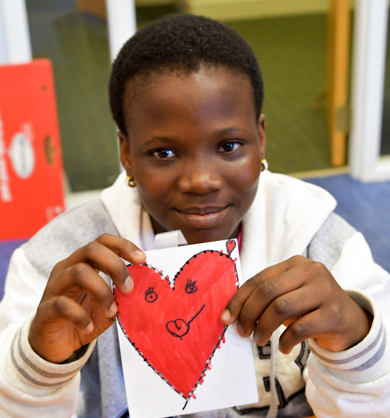Inn resident Mercy holding up a heart she drew