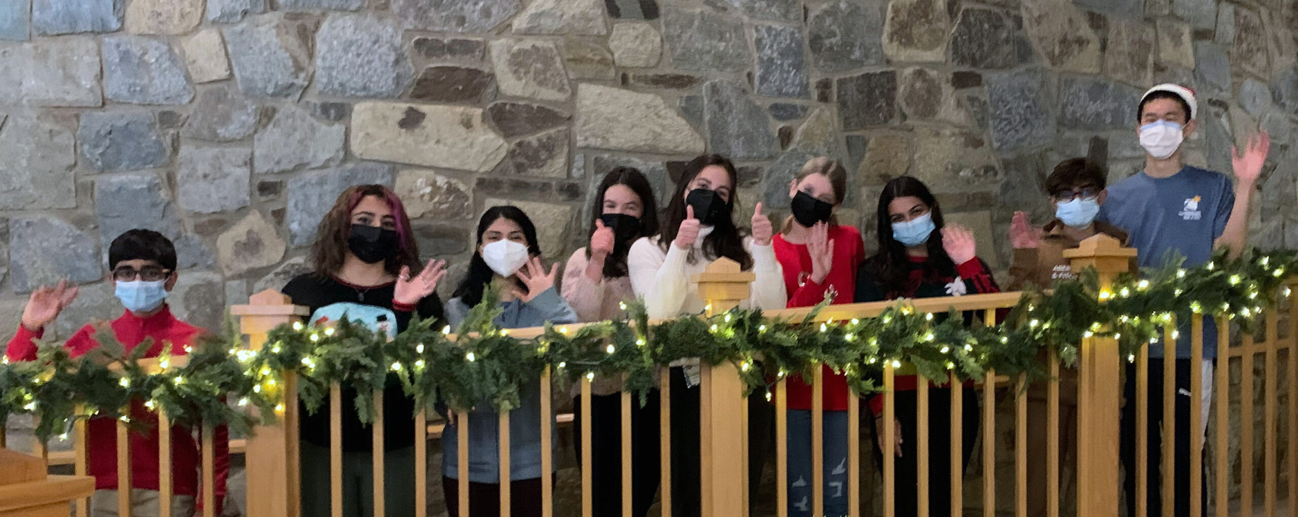 photo of several teens lining the railing and waving