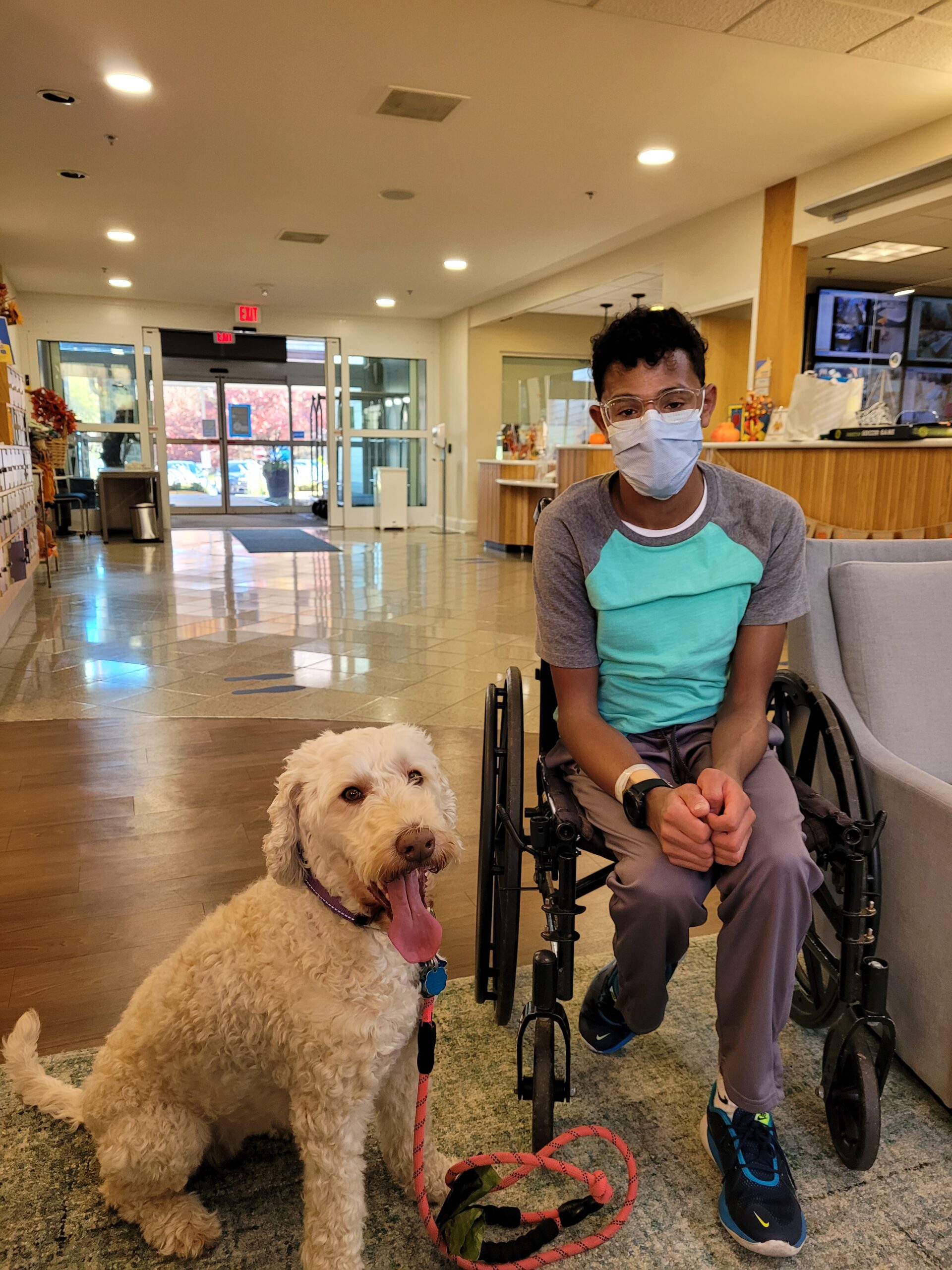photo of young man in wheel chair with therapy dog