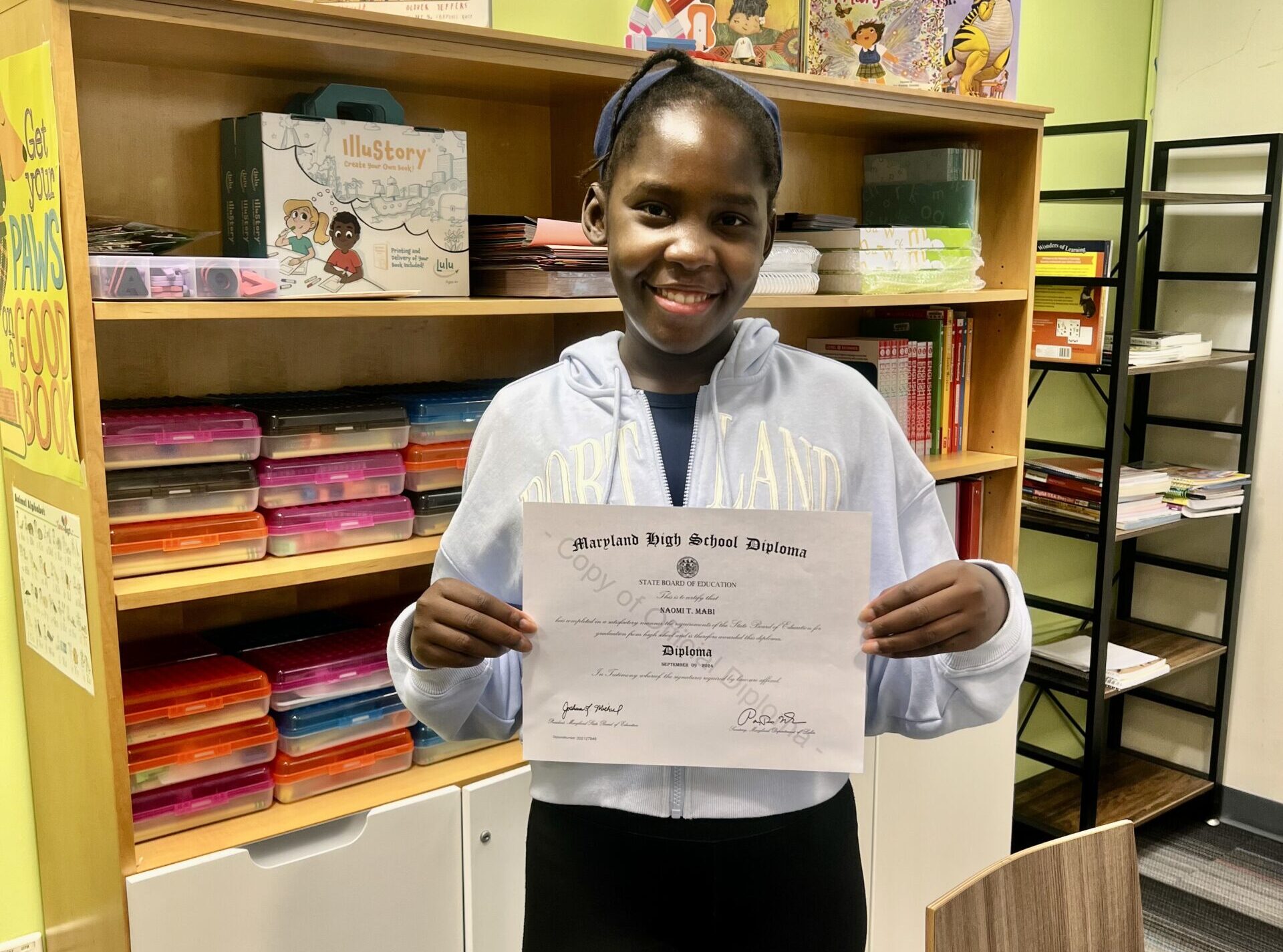 Naomi holding GED diploma